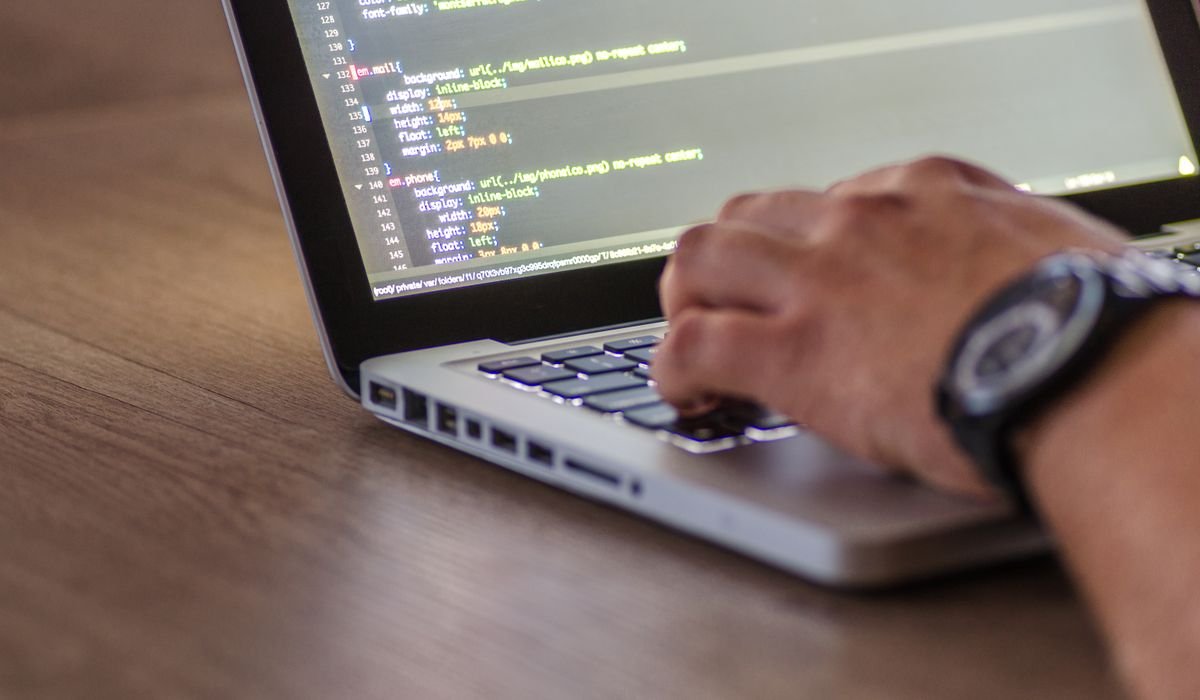 Persona programando en un ordenador, representando un agente de IA
